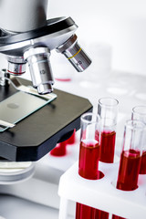 blood in glass tubes on background of microscope