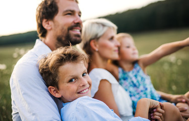 Obraz premium Young family with small children in summer nature at sunset.