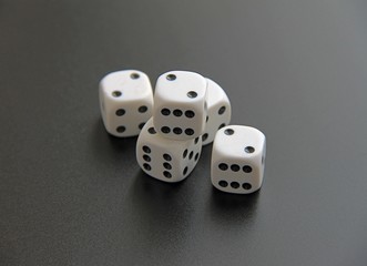 five old white dices on black background