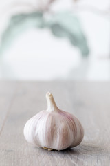 whole fresh garlic on wooden and pattern wallpaper in background