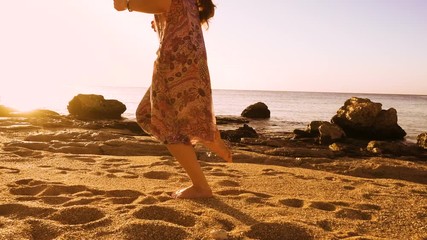 Young girl running barefoot at the sunny beach
