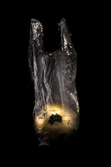 A concept golden earth inside transparensy plastic bag isolated on black background