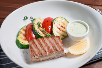 Tuna steak grilled with zucchini and paprika. Close up