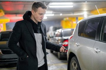 man opens his car in the underground parking zone f