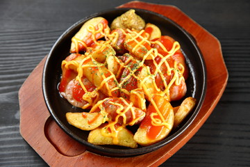 grilled sausage and potatoes on iron plate
