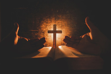 Vintage photo of hand with Bible praying , Hands folded in prayer on a Holy Bible , Spirituality...