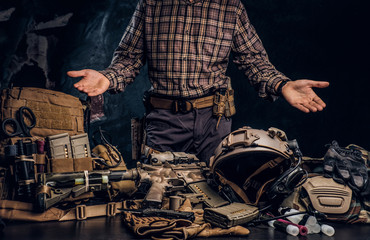 Man in a checkered shirt showing his military uniform and equipment. Modern special forces...