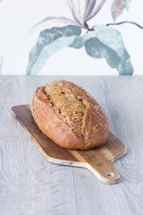 bread on cuttingboard infront of flower pattern wallpaper