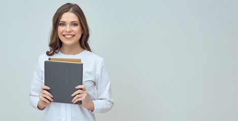 Smiling woman teacher wearing white shirt holding books.