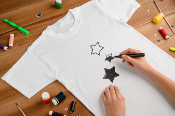 Woman drawing stars on t-shirt