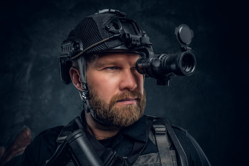 Close-up portrait of a bearded special forces soldier observes the surroundings in night vision...