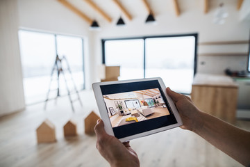 Midsection of man with tablet, looking at interior design sketches. A new home concept.