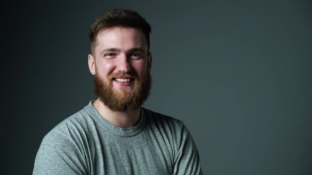 Young bearded hipster man happy laughing looking at camera