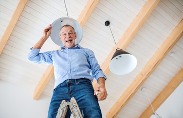 A senior man furnishing new house, having fun. New home concept.