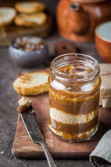Homemade salted caramel sauce with cookies in jar on rustic background.