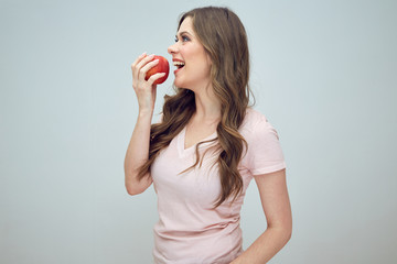 young woman eating red apple.