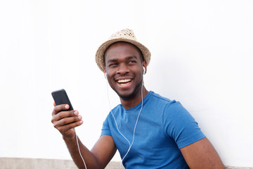 Fototapeta na wymiar happy african american man listening to music with smart phone and earphones