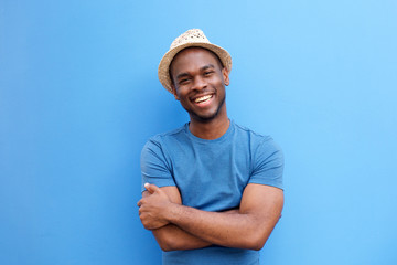 handsome young black guy smiling with hat against blue background