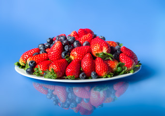 Three kinds of fresh berries on a white plate