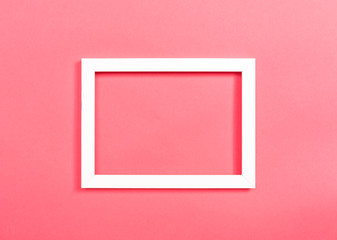 Empty photo frame on a pink paper background