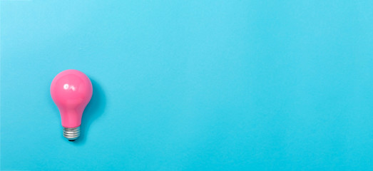 Colored light bulb on a blue paper background