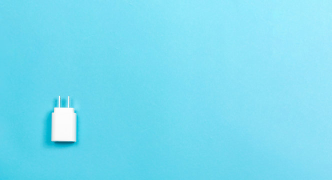 Charger Plug Adapter On A Blue Paper Background