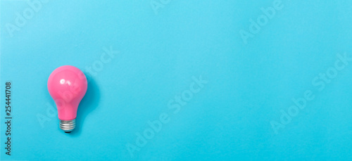 Colored light bulb on a blue paper background