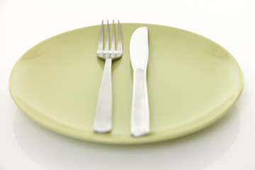 green dish on the white table with cutlery meaning FINISHED