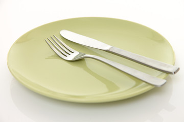 green dish on the white table with cutlery meaning FINISHED