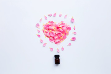 Bottle of rose essential oil for aromatherapy on white