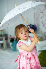 Little girl holding an umbrella for the sun.