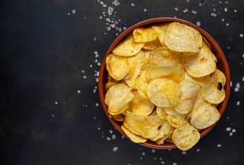 Crispy chips in a bowl on a stone background