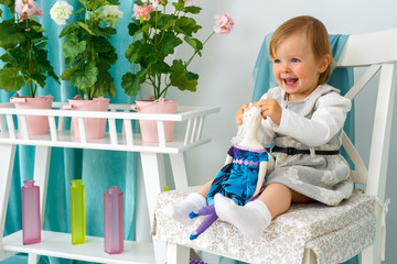 The little girl is sitting on a big chair and smiling.