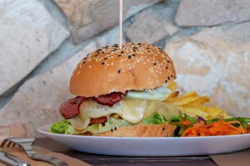 big tasty hamburger on a plate in a restaurant