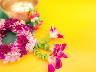 web banner design for spring and summer season festival concept from minimal flat lay tropical flower with orchid ,rose decorate on pastel yellow background for songkran ceremony 