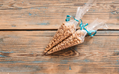 Roasted, salted peanuts are placed on a wooden background