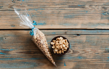 Roasted, salted peanuts are placed on a wooden background