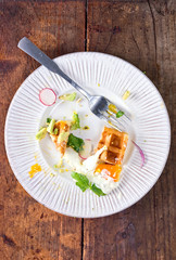Savory waffles with fresh vegetable salad, avocado and egg on wood background. Flat lay, top view, copy space.