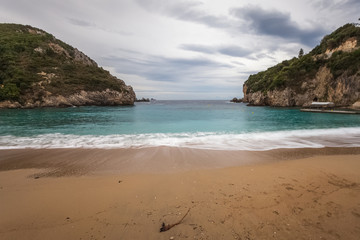 Fototapeta na wymiar Paleokastritsa beach with Kolyviri island background on a rainy day