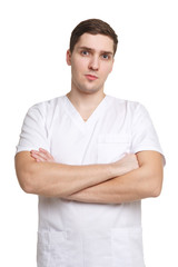 Young medical worker in overalls standing with arms folded, isolated on white background.