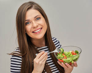 young woman keeps vegetable diet, eating green salad.