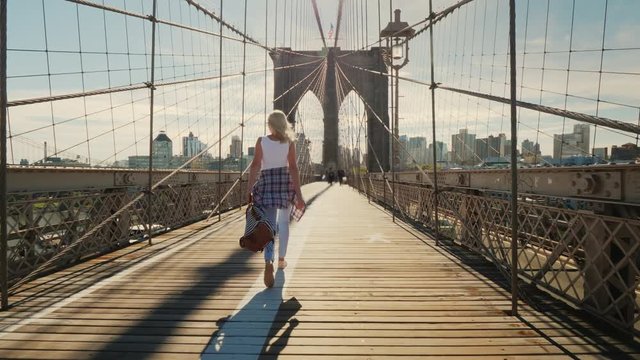 Active young woman walks on the Brooklyn Bridge in New York