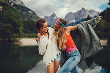 Two young women tourist  have fun on the lake