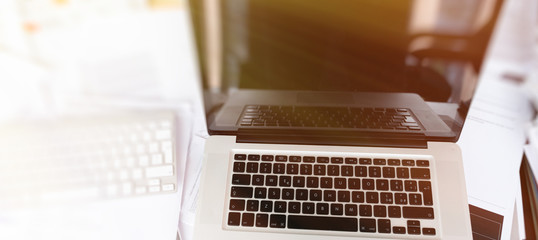 Modern laptop in the middle of a mess of papers