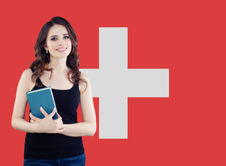 Study, internship and work in Switzerland concept. Beautiful smart woman on swiss flag background
