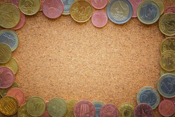 Top view Euro coins on cork board as business, money, banking, currency concept - can input center...