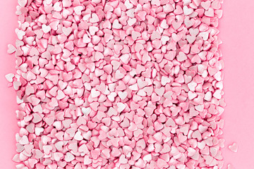 Trendy shiny silver pink hearts background of cake candy sprinkles in flatlay with copy space, for feminine blogger or festive love concept