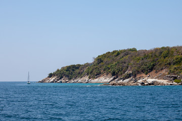 Fototapeta na wymiar blue sea with white sand on the background of the jungle and rocks. Thailand Racha Island