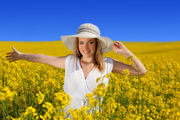 Naklejka na ściany i meble young woman in yellow field of Canola