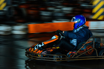 Fototapeta na wymiar Dynamic karting competition at speed with blurry motion on an equipped racecourse